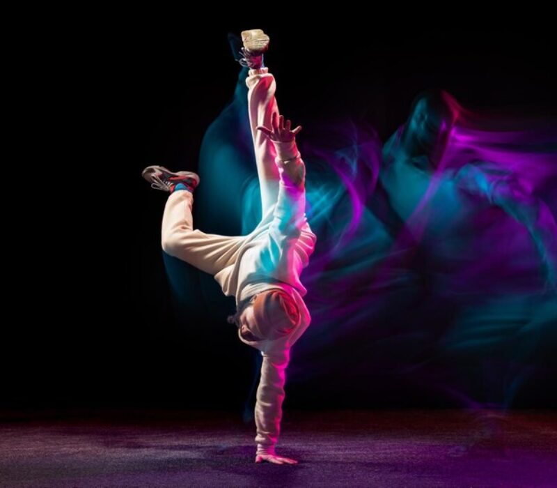 young-sportive-man-daancing-breakdance-isolared-black-backgrounf-neon-with-mixed-lights_155003-45629